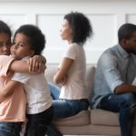 Sad african children embracing upset at parents fight at home