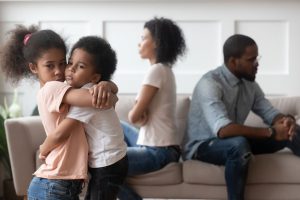 Sad african children embracing upset at parents fight at home