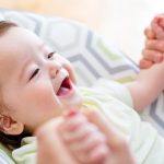 Happy baby boy playing with his parent