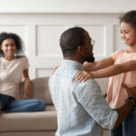 Happy black dad and daughter hug reunited after parting