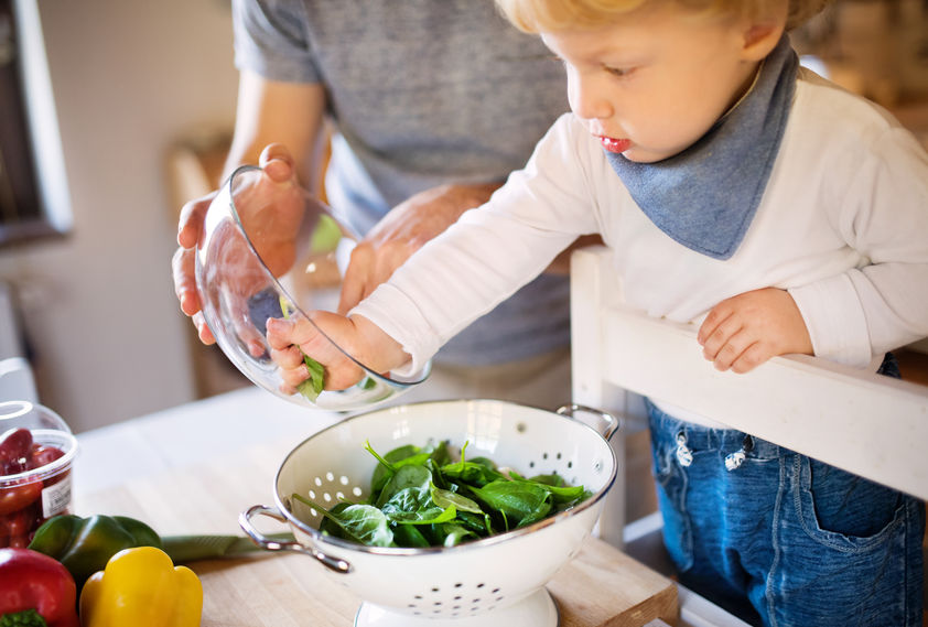 Young father with a toddler boy cooking.