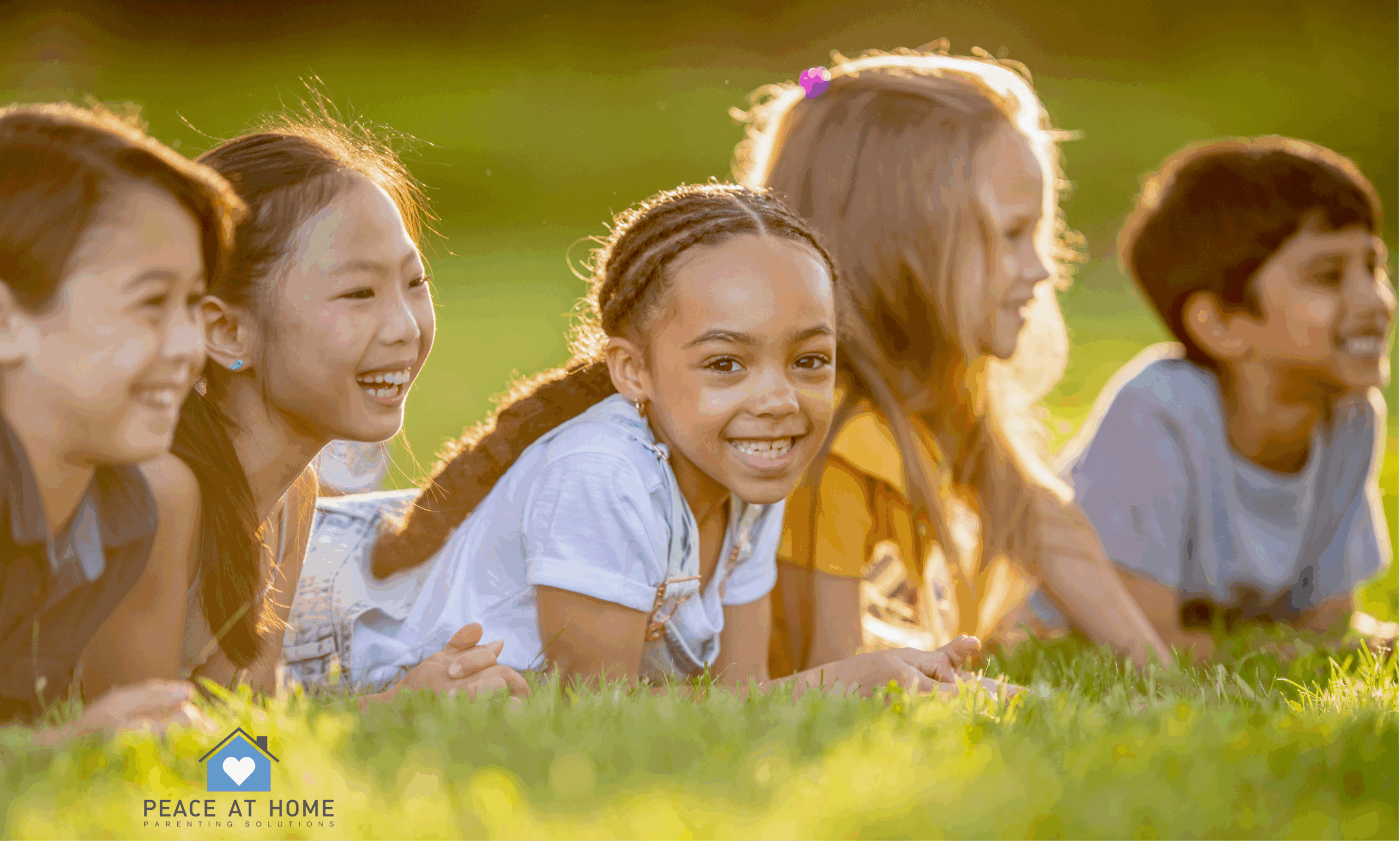 school age kids laying in grass outside listening playing fun