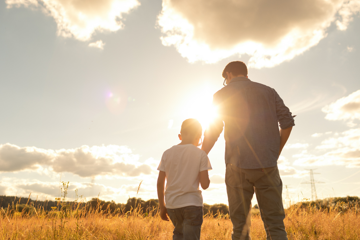 Father and son bonding and watching a beautiful sunset together - parenting benefits for employees - Peace at Home Parenting Solutions